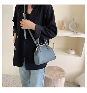 Detailed view of blue retro shell handbag featuring litchi texture and metal buckle clasp