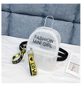 Détail du mini sac à dos en PVC transparent avec bretelles noires et breloques jaunes