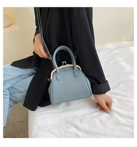Blue-grey shell handbag with lychee texture and metal doctor-style closure on model