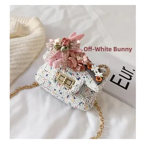 Dettaglio della mini borsa in tweed crema con coniglio di peluche e catena dorata