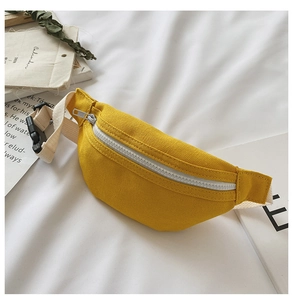 Close-up of ginger yellow canvas belt bag with white zipper and soft fabric strap