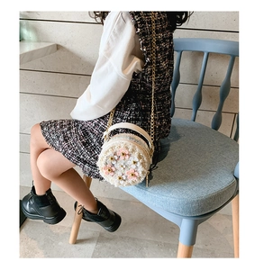 Détail du mini sac rond en tweed blanc avec fleurs 3D roses et décorations en perles