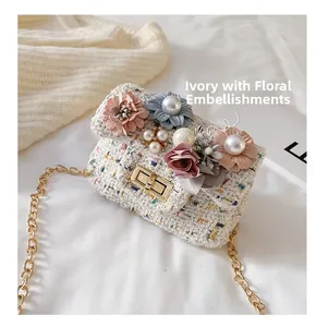 Dettaglio borsa a tracolla in tweed con fiori in tessuto fatti a mano e perle