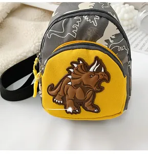 Detailed close-up of gray dinosaur waist bag with yellow pocket and 3D triceratops motif