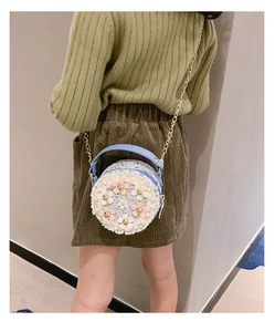Détail du mini sac rond en tweed avec fleurs, perles et bandoulière chaîne dorée