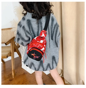 Detail of red dinosaur chest bag showing the embroidery and adjustable black strap