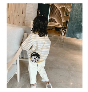 Gros plan d'appliques florales 3D sur un sac à bandoulière rond noir avec chaîne en métal