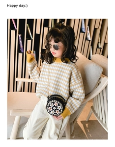 Détail d'un sac à bandoulière rond noir pour enfant avec fleurs roses et perles