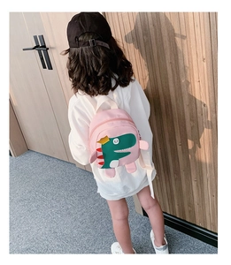 Sac à dos rose dinosaure pour enfant avec détails 3D porté par un petit mannequin