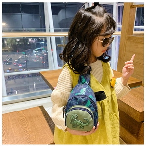 Detailed close-up of a blue canvas kids chest bag featuring green dinosaur patterns