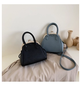 Detail of vintage textured leather shell bags in black and blue with gold metal clasps