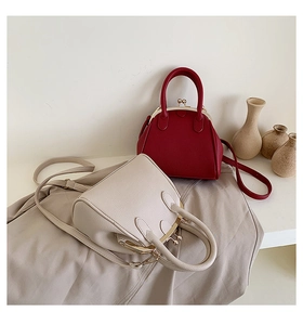 Detailed view of red and beige lychee pattern shell bags with vintage metal clasps