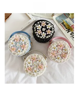 Détail de sacs en tweed à fleurs avec perles et marguerites en quatre coloris