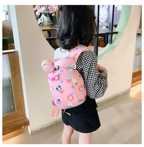 Pink toddler backpack with cartoon ears and safety harness shown on child's back