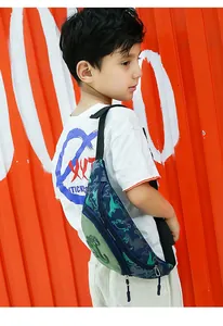 Détail du sac de poitrine dinosaure pour enfant avec motifs et écusson 3D sur tissu bleu