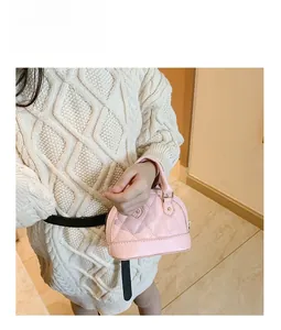 Detail of pink quilted shell bag for kids with gold hardware and top handle