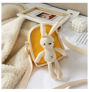 Dettaglio borsa a tracolla in tela gialla con coniglio di peluche 3D e cinturino in tessuto