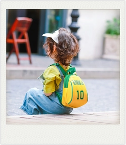 Detail of cute yellow kids backpack with Neymar Jr 10 print and green piping