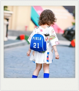 Close-up of bright blue kids backpack with white Pirlo 21 text in outdoor setting