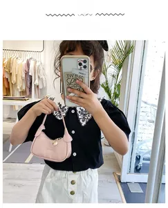 Détail du mini sac à bandoulière rose pour enfants avec pendentif cœur doré et zip