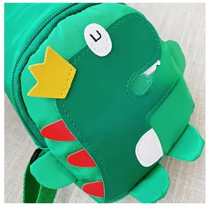 Detailaufnahme der grünen Dinosaurier Kindertasche mit gelber Krone und roten Zacken
