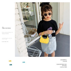 Enfant mannequin asiatique portant un mini sac à main baguette jaune en similicuir chic