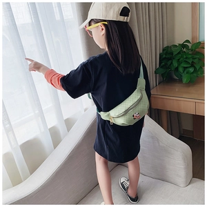 Détail du sac banane enfant vert clair avec écusson Mickey Mouse et motifs vintage chic