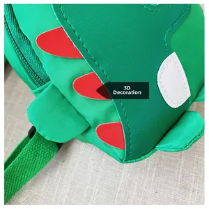 Detail der Kinder-Dinosaurier-Tasche mit roten 3D-Schuppen und grünem Stoff