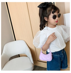 Gros plan d'un enfant portant un mini sac baguette violet pastel pour petite fille