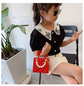 Details der roten Kinderhandtasche aus Lackleder mit Perlen griff und Goldkette