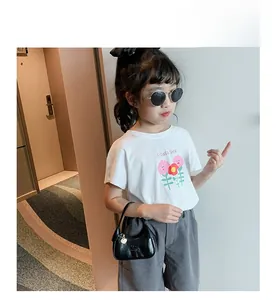 Gros plan du motif Flower Shop sur t-shirt blanc pour enfant avec fleurs roses