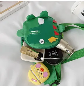 Detail view of the interior capacity showing a smartphone and makeup in a green dinosaur bag