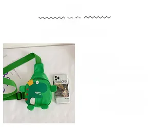 Größenvergleich der grünen Dinosaurier-Kindertasche neben einem Smartphone
