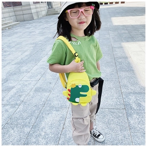 Detail van gele crossbodytas voor kinderen met groene dinosaurus-patch en verstelbare riem