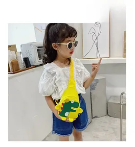 Detailed view of child wearing yellow canvas dinosaur chest bag with adjustable strap