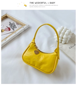 Détail du mini sac à main jaune en cuir PU avec breloque cœur et logo embossé