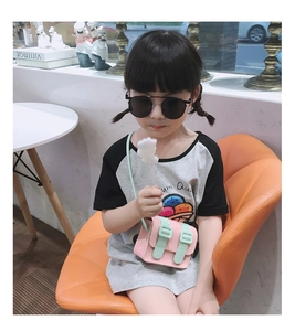 Kid's mini crossbody bag in pink and mint green shown worn by a child model
