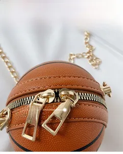 Close-up of basketball-shaped mini bag featuring dual gold zippers and lychee grain leather