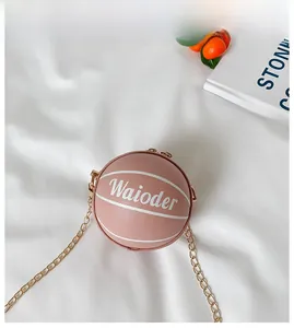 Detailed close-up of pink basketball-shaped kids purse with gold chain and zipper closure