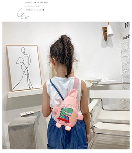 Rosa Kinder-Brusttasche mit Cartoon-Dinosaurier am Kindermodel in modernem Ambiente