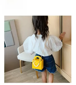 Gelbe Kinderhandtasche aus Lackleder mit großen Perlen und goldener Kette im Detail