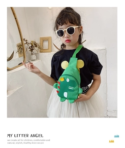 Detail shot of a child wearing a green cartoon dinosaur chest bag with adjustable strap