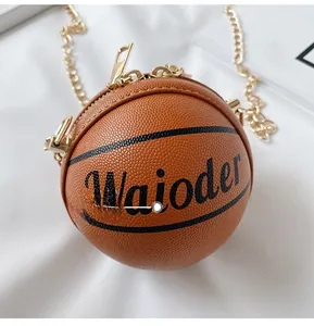 Detail view of basketball-shaped shoulder bag featuring grainy texture and gold chain strap