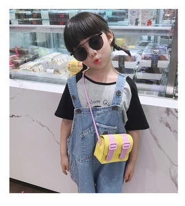 Detailed view of kids mini yellow crossbody bag with pink straps and PU leather texture
