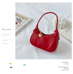 Gros plan d'un mini sac rouge pour enfants avec pendentif coeur et logo élégant