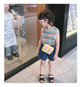 Fashionable girl wearing a mini color-block Cambridge crossbody bag with a knit striped top