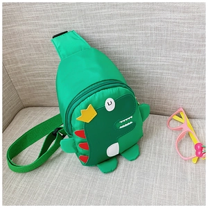 Detail der grünen Dino-Brusttasche mit kleiner gelber Krone für Kinder im Außenbereich