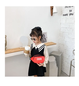 Détail d'un sac banane rouge en toile pour enfants avec fermeture éclair et sangle noire