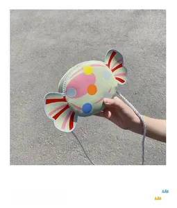 Detail of candy-shaped mint green crossbody bag with colorful polka dots for kids