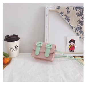 Detail of pink and mint green mini satchel bag for kids on a floral decorative table